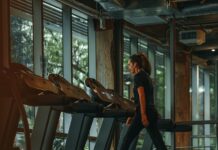 규칙적인 운동이 건강에 미치는 긍정적인 영향 a woman running on a treadmill in a gym