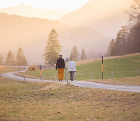야외 활동과 운동이 주는 이점 woman in black jacket and white pants walking on road during daytime