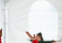 스트레칭으로 굳은몸을 풀어보 woman in red long sleeve shirt raising her hands