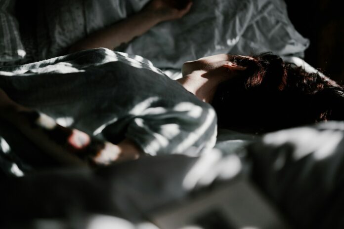 Photo by Annie Spratt a person laying in a bed under a blanket
