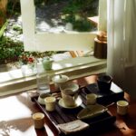 나를 돌보는 작은 실천, 일상 속 웰니스 문화 확산 Tea set arranged on a wooden tray by the window.